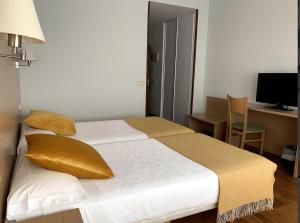 a bedroom with a bed with yellow pillows and a desk at Hotel San Millán in Santander