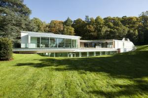 a house on a hill with a large yard at Coworth Park - Dorchester Collection in Ascot