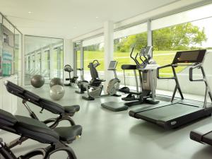 a gym with several treadmills and elliptical machines at Coworth Park - Dorchester Collection in Ascot