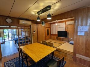 una sala da pranzo con tavolo in legno e TV di Yuzan apartment Sanjo a Nara