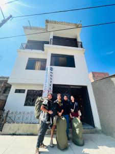 un grupo de personas de pie en frente de un edificio en Montañero Hostel en Huaraz