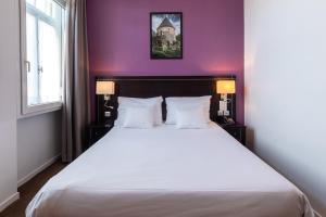 - une chambre avec un grand lit blanc aux murs violets dans l'établissement Hôtel Le Mondon Metz, à Metz