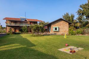 uma casa com um quintal com um parque infantil em frente em SaffronStays Lake House Bouganvillea, Nashik - rustic pool villa with great lake views and patio dining em Nashik