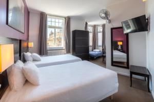 - une chambre avec un grand lit blanc et un miroir dans l'établissement Hôtel Le Mondon Metz, à Metz