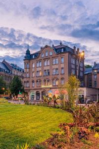 un grand bâtiment avec une pelouse devant lui dans l'établissement Hôtel Le Mondon Metz, à Metz