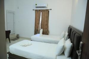 a bedroom with two beds and a window at CHRISTIAN GUEST HOUSE in Vellore