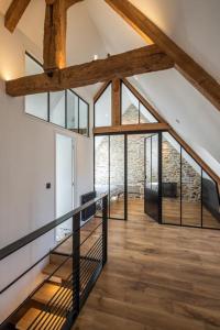 Habitación en el ático con ventanas de cristal y suelo de madera. en Appart Halo et Duplex Les Filles, en Dinan