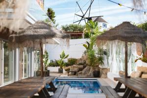 - une piscine avec bancs et parasols dans l'établissement The Salty Pelican Yoga & Surf Retreat, à Ericeira