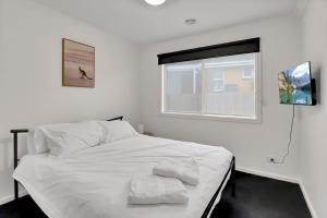 un letto bianco in una camera da letto con finestra di Retreat on Francis I Short and Long Stays a Geelong