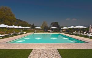 een groot zwembad met stoelen en parasols bij Hotel Villa Cheli in Lucca