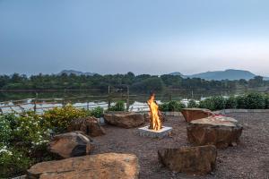 uma fogueira num quintal com pedras em SaffronStays Lake House Marigold, Nashik - rustic cottages with private plunge pool em Nashik