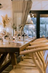 una larga mesa de madera con copas de vino. en Santa Lucia Maccarese - Residenza Agricola, en Maccarese