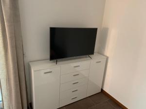 uma televisão de ecrã plano em cima de uma cómoda branca em Wohlfühl-Apartment em Ettlingen