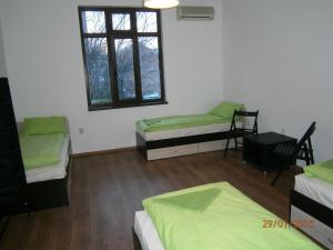 Zimmer mit 3 Betten und einem Fenster in der Unterkunft Ivory Tower Hostel in Sofia