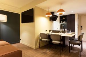 - une cuisine et une salle à manger avec une table et des chaises dans l'établissement RockyPop Grenoble Hotel, à Grenoble