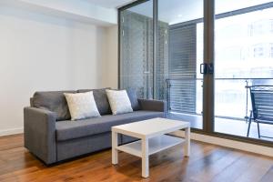 sala de estar con sofá y mesa en Sydney CBD Modern 2 bedroom Apartment, en Sídney