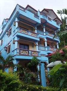 un edificio azul con balcones y árboles en Ocean Breeze Inn en Boracay