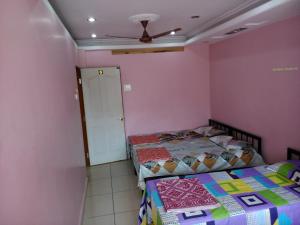 una camera con 2 letti e un ventilatore a soffitto di Ambai Guest House a Kolhapur