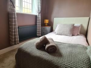 una camera da letto con un letto e un asciugamano sopra di Spacious, 5 bed house for 9 in Chester a Chester