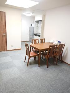 a dining room with a wooden table and chairs at Guesthouse Kyoto Abiya in Kyoto