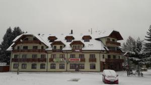 a large building with a snow covered roof at Aparmánový dom Kamzík,Apartmán 42,Donovaly in Donovaly