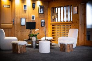 een woonkamer met 2 stoelen en een tafel en houtblokken bij Le Chalet d'Antoine - Centre de Megève in Megève