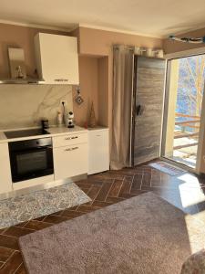 a kitchen with white cabinets and a door leading to a patio at Grange chic in Sestriere