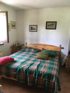 a bedroom with a bed with a plaid blanket at Casa vacanze Ravascletto in Ravascletto