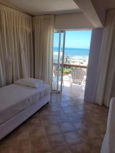 Schlafzimmer mit einem Bett und Meerblick in der Unterkunft Hotel Aquarella in Punta Del Diablo