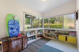 Habitación con tabla de surf y estantería de libros en 15 Clarke Street Narooma, en Narooma