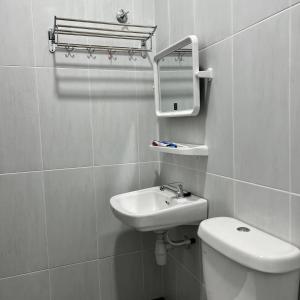 a bathroom with a sink and a toilet and a mirror at Homestay Ayer Keroh Tasik Utama in Ayer Keroh