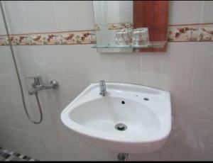 y baño con lavabo blanco y espejo. en Griya Sukatno, en Magelang