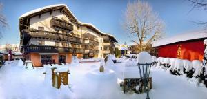 eine schneebedeckte Straße vor einem Gebäude in der Unterkunft Hotel Hirsch in Oberstaufen