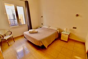 1 dormitorio con 1 cama, 1 silla y 1 ventana en Hotel Ibiza, en Sitges