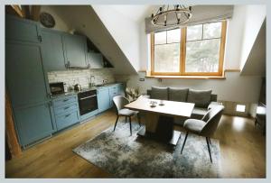 a kitchen with blue cabinets and a table and chairs at Nora Berry in Nida