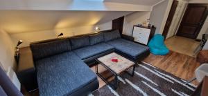 ein Wohnzimmer mit einem schwarzen Sofa und einem Tisch in der Unterkunft Apartman Deluxe villa Barbora Hrabovo in Ružomberok