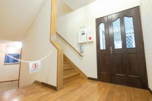 einen Flur mit Tür und Treppe mit Schild drauf in der Unterkunft STAY IN ASAHIKAWA99 in Asahikawa