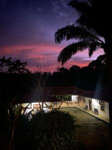 a building with a sunset in the background at Roça Vale dos Prazeres in São Tomé