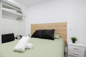 een slaapkamer met een wit bed en een houten hoofdeinde bij La Maruca Beach Santander 3000 in Santander