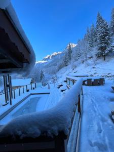 ein schneebedeckter Pool neben einem Haus in der Unterkunft Chalet Galadhrim Chamonix Mont Blanc Valley in Les Houches