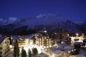 ein Resort mit schneebedeckten Bergen im Hintergrund in der Unterkunft The Capra Saas-Fee in Saas-Fee