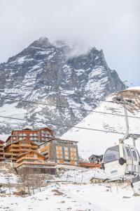 um alojamento de esqui em frente a uma montanha coberta de neve em White Angel Hotel em Breuil-Cervinia