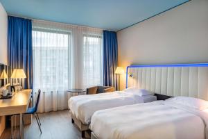 A bed or beds in a room at Park Inn by Radisson Stuttgart