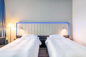 A bed or beds in a room at Park Inn by Radisson Stuttgart