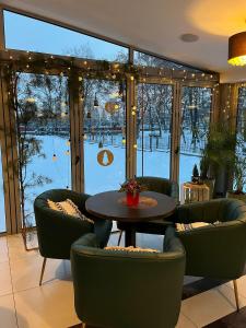 een kamer met een tafel en stoelen en een groot raam bij Hotel Gorczowski Katowice Chorzów in Chorzów