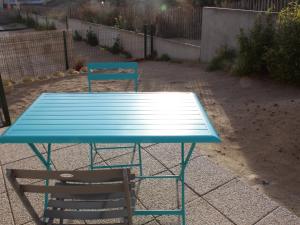 une table bleue et une chaise dans la cour dans l'établissement Charmante maisonnette à Quend Plage, 2 chambres, jardinet, parking, proche commodités - FR-1-482-45, à Quend