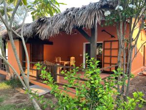 une maison avec un toit de chaume et une terrasse dans l'établissement maison vanilianadia, à Nosy Be