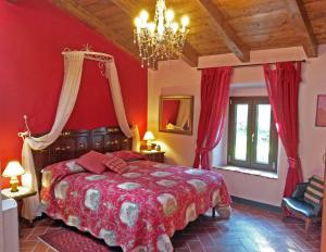 a bedroom with a bed with red walls and a chandelier at Locanda Le Panche in Pistoia