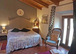 a bedroom with a bed and a chair at Locanda Le Panche in Pistoia