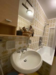 a bathroom with a white sink and a tub at Skyline su Sestriere in Sestriere